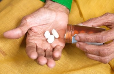 senior women hand's taking medicine, close up .