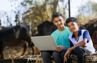 Cute little Indian/Asian boy studying or playing game with laptop computer